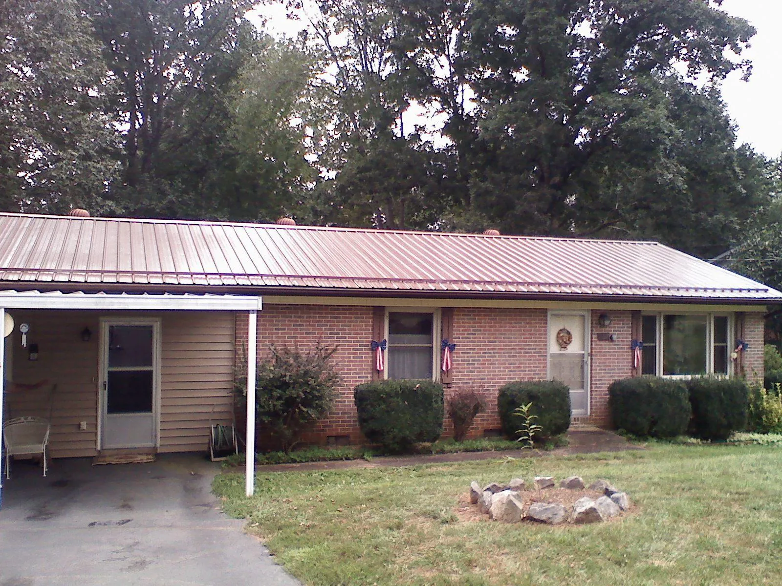 Bronze metal roof and carport on a brick ranch home — Roof Repair work by our crew in Boston